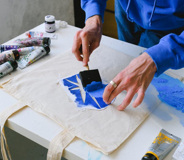 Hands painting with blue paint