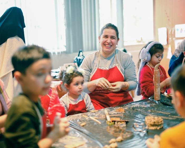 A smiling art teacher with kids at a craft table